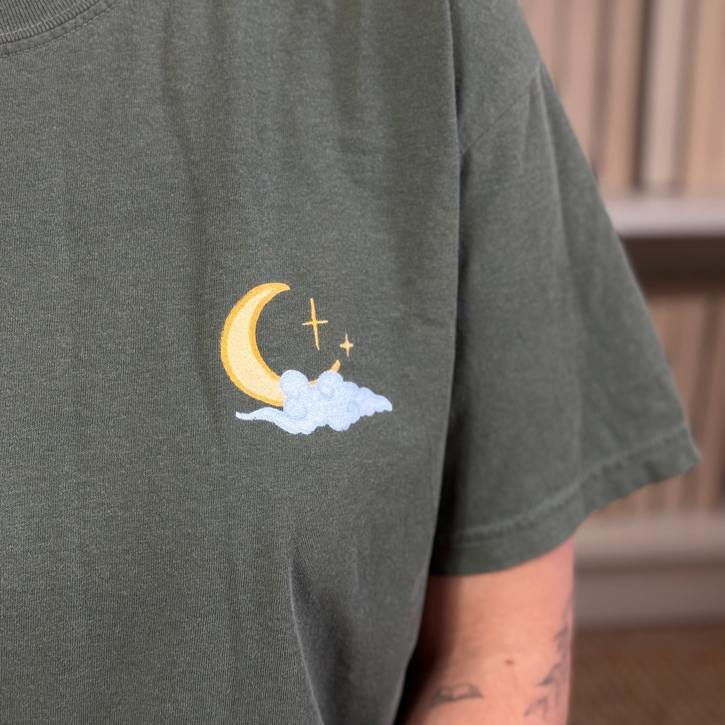 Fantasy Premium T-Shirt in grün mit kleinem Motiv vorne aus Mond und Wolke.  Nahaufname. 